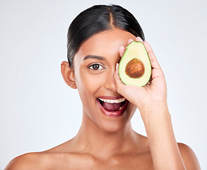 Image showing Avocado, portrait and natural skincare of woman in studio for vitamin c benefits, eco cosmetics and nutrition. Face of happy indian model, healthy food and beauty for omega 3 diet on white background