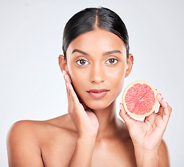 Image showing Face, woman with grapefruit and natural beauty, facial and eco friendly skincare portrait on white background. Wellness, fruit and vegan cosmetic product with glow, vitamin c and citrus in studio