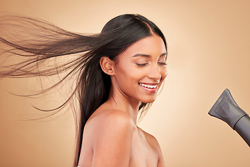 Image showing Beauty, hairdryer and young woman in a studio with salon keratin treatment for wellness. Hair care, cosmetic and Indian female model with cosmetology tool for hairstyle isolated by a brown background