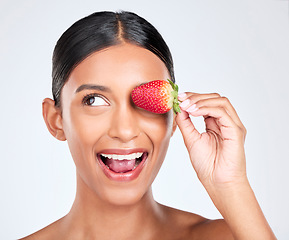 Image showing Health, smile and woman with a strawberry in studio for healthy diet snack for nutrition. Wellness, beauty and young Indian female model with fruit for natural skin detox routine by white background.