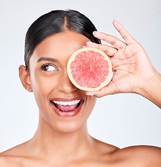 Image showing Grapefruit, happy woman and face with beauty, healthy and natural skincare with citrus fruit on white background. Wellness, vitamin c and smile for cosmetics product, eco friendly and vegan in studio