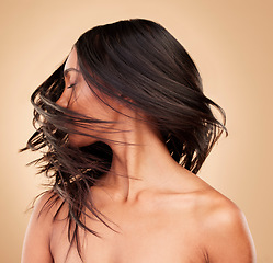 Image showing Hair, beauty and woman shake head in studio isolated on a brown background. Hairstyle care, natural cosmetics and model in salon treatment for texture growth, health or wellness aesthetic with wind
