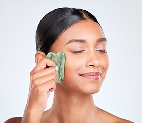 Image showing Woman, face and gua sha, natural beauty and tools with jade stone for skincare isolated on white background. Facial massage, facelift and grooming with skin glow, dermatology and wellness in studio