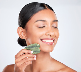 Image showing Woman, face and gua sha, beauty and tools with jade stone for natural skincare isolated on white background. Facial massage, facelift and grooming with skin glow, dermatology and wellness in studio