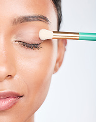 Image showing Woman, makeup and eye brush in studio for beauty, skincare or apply facial powder on white background. Closeup, face of model and cosmetic tools for eyeshadow glow, dermatology and aesthetic makeover