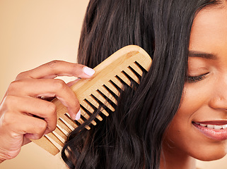 Image showing Comb, closeup and young woman in studio with clean salon treatment hairstyle for wellness. Health, hair care and zoom of female model with cosmetic tool for haircut maintenance by brown background.