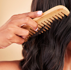 Image showing Comb, hair care and closeup of woman in studio with clean salon treatment hairstyle for wellness. Beauty, cosmetic and zoom of female model with tool for haircut maintenance by a brown background.
