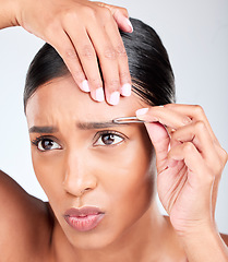 Image showing Hair removal, pain and woman with tweezers in studio, tools for self care and skincare grooming. Facial, dermatology and eyebrow maintenance, face of model on white background for clean skin glow.