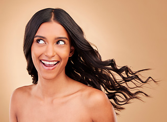 Image showing Thinking, hair care and happy woman with wind growth or beauty isolated in a studio brown background with strong texture. Aesthetic, natural and young person with cosmetics for health and shine