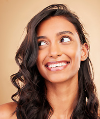 Image showing Curly hair, beauty and smile of woman in studio isolated on a brown background. Hairstyle care, natural cosmetics and Indian model thinking in salon treatment for health, hairdresser and balayage