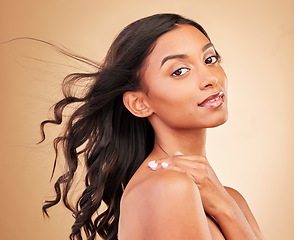 Image showing Curly hair, face and woman in wind at studio isolated on a brown background. Hairstyle breeze, natural cosmetics and portrait of Indian model in salon treatment for beauty, hairdresser and balayage