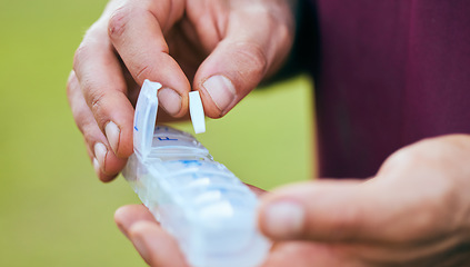 Image showing Pills, medicine box and hand closeup of a sport athlete on a soccer field with tablet and drugs for health. Supplements, container and outdoor with a man holding wellness and medication inventory