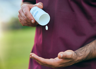 Image showing Pill box, medicine and man hand closeup of a sport on a soccer field with tablet and drugs for health. Supplements, container and outdoor with an athlete holding wellness and paracetamol medication