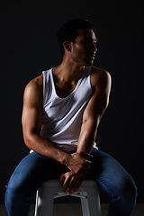 Image showing Body, muscle and sexy man on chair in studio with fitness inspiration, aesthetic and sensual fashion. Art, wellness and performance, muscular male model on black background thinking in dark lighting.