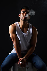 Image showing Smoking portrait, sexy man and chair in studio in fitness, beauty aesthetic and strong sensual fashion. Art, body and male model with muscle, cigarette and jeans on black background in dark lighting.