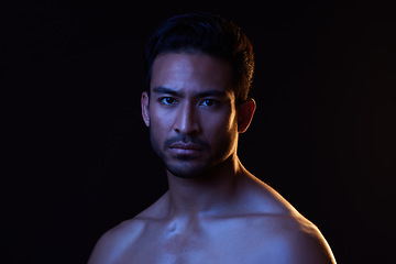 Image showing Blue light, man and portrait with creative, art and dark background in studio. Sexy, serious face and male model from Indonesia with skin glow, grooming care and wellness for skincare treatment