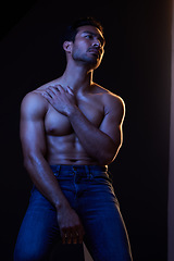 Image showing Sexy, muscle and man with fitness, wellness and posing on a dark studio background. Person, guy and model with jeans, shirtless and atmosphere with training, power and body goals with aesthetic