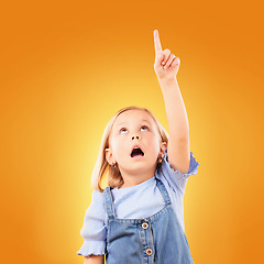 Image showing Child, surprise and pointing up with hand in studio for advertising, announcement or promotion. Shocked girl kid on a orange background for gesture, mockup space or sign for attention, fear or scared
