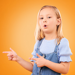 Image showing Child, portrait and girl with finger gun in studio for advertising, announcement or promotion. Young kid on orange background for hand gesture, pointing or sign for direction, attention or marketing