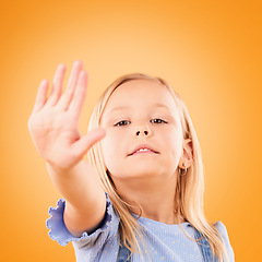 Image showing Stop, hand and portrait of girl child in studio with no, warning or vote on orange background space. Protest, palm and face of kid with emoji for control, power or voice, opinion or limit choice