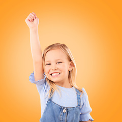 Image showing Hand up, portrait and girl child in studio happy, excited and celebrating success on orange background space. Face, smile and kid winner with victory fist for good news, promotion or prize giveaway