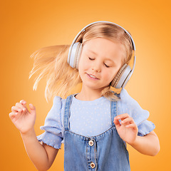 Image showing Headphones, dancing or child streaming music to relax with freedom in studio on orange background. Hair, moving or girl dancer listening to a radio song, sound or gospel on an online subscription