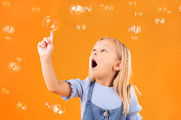 Image showing Girl child, surprise and pop bubbles, playing and fun with youth isolated on orange background. Liquid soap, wow and amazed with kid from Australia in studio, playful and toys with childhood