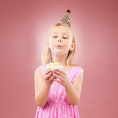 Image showing Blow candle, birthday and child with cupcake for holiday party, happy celebration and a wish. Young girl kid on a pink background for surprise, cake or celebrate achievement with a dessert and joy