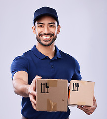 Image showing Smile, portrait and delivery man giving boxes in studio, safe transport for ecommerce supplier product. Package, logistics and happy courier person on white background for online sales and services.