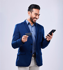 Image showing Credit card, phone and a business man in studio for online shopping, fintech payment or website. Asian person with a smartphone and finance for savings, e commerce or banking on a grey background