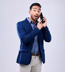 Image showing Talking, busy and a man on a phone call with a studio background for business or networking. Serious, communication and an Asian businessman with a conversation on a mobile for work or negotiation