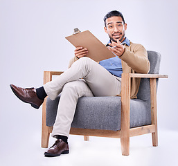 Image showing Portrait, question and a man psychologist in a chair on a white background in studio to listen for diagnosis. Psychology, mental health and documents with a person counseling during a therapy session