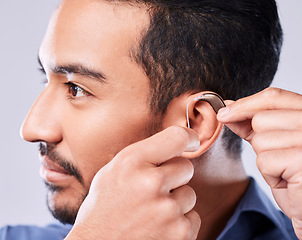 Image showing Deaf, cochlear and asian man ear in studio with hearing aid, audio and implant installation. Audiology, sound waves and face of Japanese guy with a disability, vibration or communication device