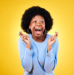 Image showing Woman, fingers crossed and happy surprise in studio for winning announcement, hope or wow for prize deal. Excited african model wish for good news, lucky giveaway winner or shout on yellow background