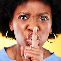 Image showing Angry portrait, woman and secret on lips in studio for privacy, drama and noise on yellow background. Face closeup of annoyed african model warning with finger emoji for whisper, quiet or voice sign