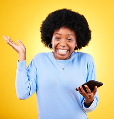 Image showing Phone, excited and a woman in studio for win, competition announcement and wow emoji. Happy black person or winner with a smartphone on a yellow background for success, social media crush or chat