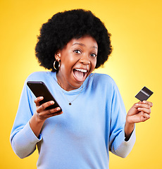 Image showing Happy black woman, portrait and phone with credit card in online shopping against a yellow studio background. Excited African female person with afro on smartphone for ecommerce, payment or banking