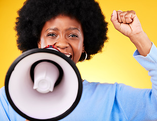 Image showing Black woman, portrait and megaphone with fist in protest, fight or march against a yellow studio background. African female person or activist with noise, bullhorn or loudspeaker in voice or justice