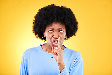 Image showing Angry portrait, woman and secret for noise, drama and privacy on yellow background in studio. Face, moody african model and warning with finger on lips for whisper sign, quiet emoji and silence voice