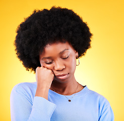 Image showing Tired, black woman and hand on face in studio looking sad, fatigue and burnout of depression and mental health. Exhausted, person and stress with crisis, anxiety and problem on yellow background