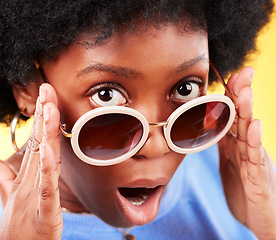 Image showing Surprise, black woman and shock on face with sunglasses, fashion and crazy sale, deal or offer in studio background. Confused, face and African person with shocked, wow or emoji for promotion