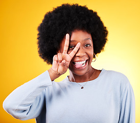 Image showing Peace, tongue out and portrait of a woman in studio with fun emoji, silly face and v sign. African person on a yellow background for v symbol, motivation and review with hand gesture or vote