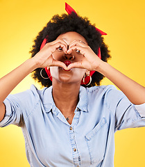 Image showing Heart, sign and happy black woman with love hand gesture as support and care isolated in a studio yellow background. Kindness, emoji and young person with gratitude, like and review symbol or icon