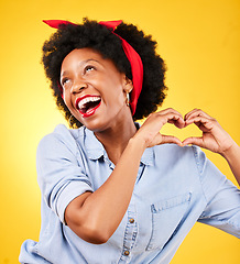 Image showing Heart, sign and happy black woman with care hand gesture as support and love isolated in a studio yellow background. Kindness, emoji and young person with gratitude, like and review symbol or icon