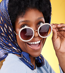 Image showing Fun, retro and woman with sunglasses and smile closeup with vintage frames accessories in studio. African female model, confidence and happy person with trendy summer fashion with yellow background