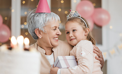 Image showing Home, hug and grandma with girl, birthday and gift with celebration, happiness and bonding. Decorations, granny or kid with a present, party or embrace with child, love or excited with care and smile