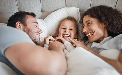 Image showing Family, bedroom and parents laughing with their daughter in the morning to relax after waking up together. Kids, love or smile with a man, woman and cute child having fun in the bed from above