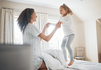 Image showing Bed, mother and girl in a home, jump and family with love, weekend break and playing together. Parent, kid and child in a bedroom, fun and happiness with activity, morning and cheerful with energy