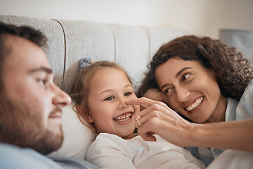 Image showing Family, bed and parents playing with their daughter in the morning to relax after waking up together. Kids, love or smile with a man, woman and cute nose of a child joking in the bedroom closeup