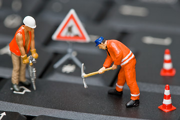 Image showing Miniature figures working on a computer keyboard.